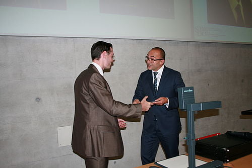 Dr. Alain Villard erhält seinen Preis aus der Hand von Kayum Guerrero.
